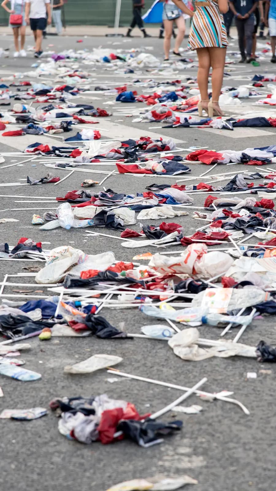 Image of a parking lot where and event was just held and rubbish covering the ground